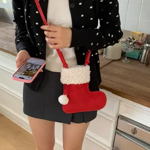 Détail d'un mini sac bandoulière de Noël en velours rouge avec bordure en peluche blanche