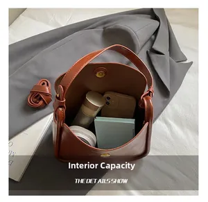 Détail de la grande capacité interne du sac seau en cuir marron au style vintage