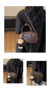 Detail of dark brown retro bowling bag with pebble texture and teddy bear charm