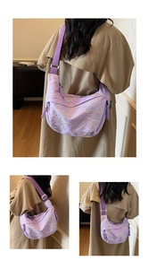 Detail of purple quilted crescent crossbody bag with colorful zigzag stitching