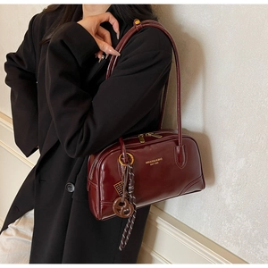 Detail of dark red glossy leather tote bag with MIKAXIQI logo and shoulder strap
