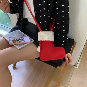 Vue détaillée d'un sac bandoulière en forme de botte de Noël rouge avec bordure en fourrure