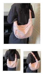 Detail of pink quilted crescent crossbody bag with colorful stitching and adjustable strap