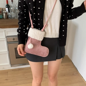 Détail du sac de Noël rose en daim avec bordure en fausse fourrure blanche et pompon