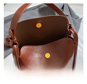 Détail du sac à main vintage en cuir marron avec sa fermeture magnétique métallique