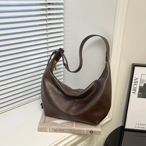 Detailed close-up of dark brown hobo shoulder bag with soft leather texture and golden zipper