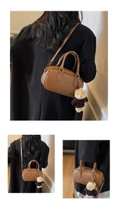 Detail of brown Boston bag featuring Mira Mira embossing and a cute teddy bear charm