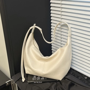 Detail shot of beige hobo shoulder bag featuring soft leather folds and metallic zipper