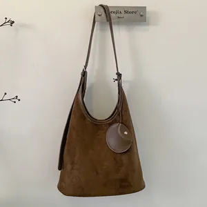 Detail of vintage matte suede shoulder bucket bag with matching small round pouch