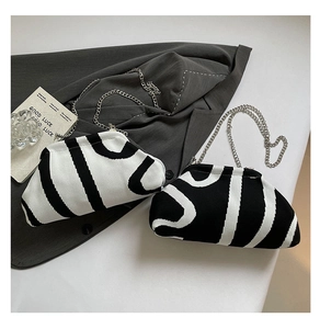Detail of knitted cloud bag with bold monochrome letter patterns and silver chain strap