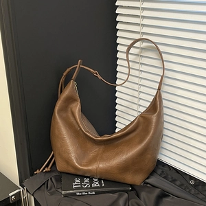 Detail of vintage brown hobo bag with vertical stitching and knotted shoulder strap