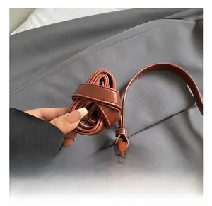 Détail de la bandoulière réglable du sac à bandoulière en cuir marron avec boucle en métal