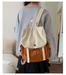 Detail of canvas backpack featuring contrast beige and caramel color-block design