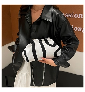 Close-up of black and white striped knitted cloud bag with silver metal chain strap