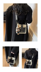 Detailed view of bucket bag with black leather pocket and woven geometric shoulder strap