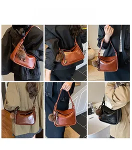 Vue détaillée du sac à bandoulière vintage avec texture brillante et pompon décoratif