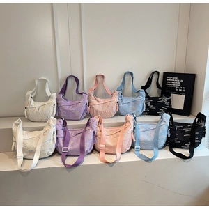Detailed view of half-moon crossbody bags with textured wavy fabric in multiple colors