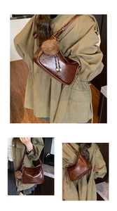 Détail d'un sac bandoulière vintage en cuir marron brillant avec pompon et breloques en métal