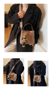 Detail view of vintage brown bucket bag with floral jacquard strap and cute bunny charm