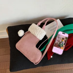 Vue détaillée du sac bandoulière en daim rose forme botte de Noël avec bordure en peluche
