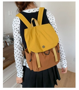 Vue détaillée d'un sac à dos en nylon imperméable avec rabat jaune et cordon de serrage