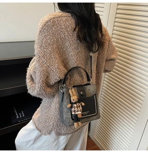 Close-up of stylish bucket bag with pearl trim, bunny charm and elegant mixed texture