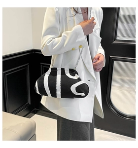 Detail of knitted cloud bag featuring white abstract stripes and silver chain strap