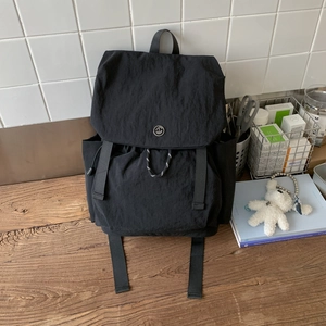 Detail view of the black waterproof nylon backpack with GM logo and drawstring closure