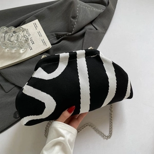 Detailed macro view of the black and white striped knitted texture on the cloud bag