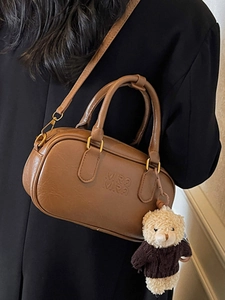 Brown leather Boston handbag with Mira Mira embossing and a cute bear keychain accessory