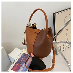 Close-up of caramel and brown leather bucket bag with pebble texture and silk scarf