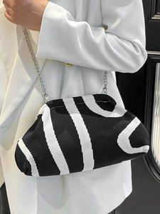 Striped knit cloud crossbody bag with silver chain strap shown in a stylish side view