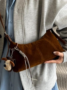 Vintage brown waxed leather crescent bag with a cute plush dog pendant charm