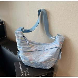 Detail of light blue cloud-textured crossbody bag with rainbow wave stitching details