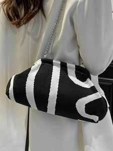 Knitted black and white striped cloud crossbody bag with elegant silver metal chain