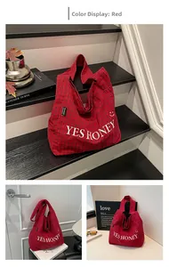 Detailansicht der roten Karo-Canvas-Tasche mit bestickten Yes Honey-Buchstaben und Smiley