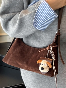 Retro dark brown suede crescent bag with adjustable strap and plush Gromit charm