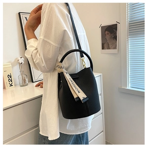 Detail of black lychee grain leather bucket bag with fashion printed scarf handle