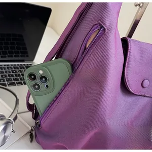 Detail showing side zipper pocket of purple tote bag with smartphone storage space