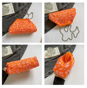 Detalle del bolso de punto con estampado de leopardo naranja y rosa con cadena