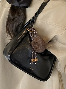 Sac à bandoulière noir brillant rétro avec large sangle et breloque décorative