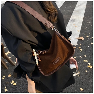 Braune Wildleder-Hobo-Tasche mit breitem Lederriemen und dekorativem Fransenanhänger