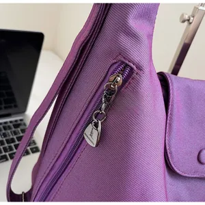 Detailed macro view of a smooth silver zipper on a purple nylon tote bag