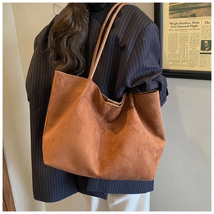 Detail view of large brown suede tote bag showing soft texture and long shoulder straps