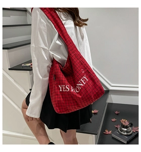 Rote karierte Segeltuchtasche mit „YES HONEY“-Stickerei, am Model getragen