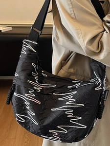 Chic black quilted crossbody bag for women with elegant wavy embroidery and adjustable strap