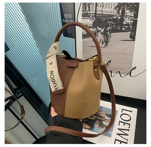 Detail of a color-block bucket bag with litchi grain leather and dual shoulder straps