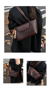 Dettaglio della borsa tote intrecciata caffè con patta in pelle e nappa in legno vintage