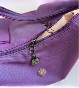 Macro shot of smooth metal zipper and purple fabric detail on a large tote bag