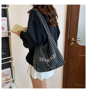 Schachbrett-Stofftasche mit YESHONEY-Stickerei in einer lässigen Lifestyle-Szene getragen